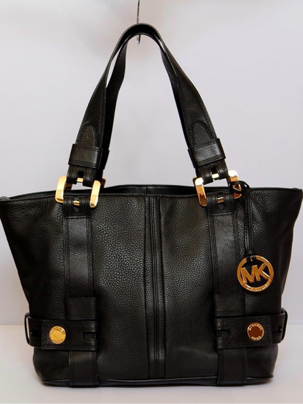 Michael Kors pebbled leather harness grab bag featuring prominent gold hardware